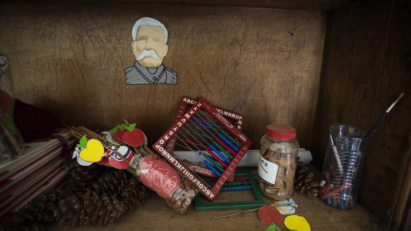 Unused school materials lay on a shelf decorated with an image of Gen. Porfirio Díaz, who was president of Mexico from 1848 to 1876, at a school in the community of Nuevo Yibeljoj, Chiapas state, Mexico, Friday, Sept. 11, 2020. Amid the new coronavirus pandemic, Mexican education officials recently said that enrollment for the new school year was down about 10%, but teachers warn that many students enrolled out of habit, but aren't participating. (AP Photo/Eduardo Verdugo)