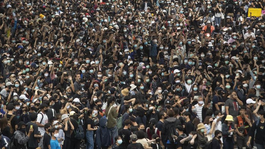 Pro-democracy protesters raise three-finger salutes, a symbol of resistance, during a protest at sky train platform in Bangkok, Thailand, Saturday, Oct. 17, 2020. The authorities in Bangkok shut down mass transit systems and set up roadblocks Saturday as Thailand’s capital braced for a fourth straight day of determined anti-government protests. (AP Photo/Sakchai Lalit)