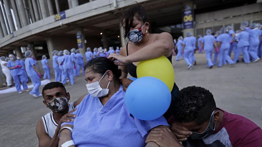 Medical workers celebrate as the last three patients are released from a field hospital at the National Stadium Mane Garrincha, after recuperating from COVID-19, in Brasilia, Brazil, Thursday, Oct. 15, 2020. (AP Photo/Eraldo Peres)