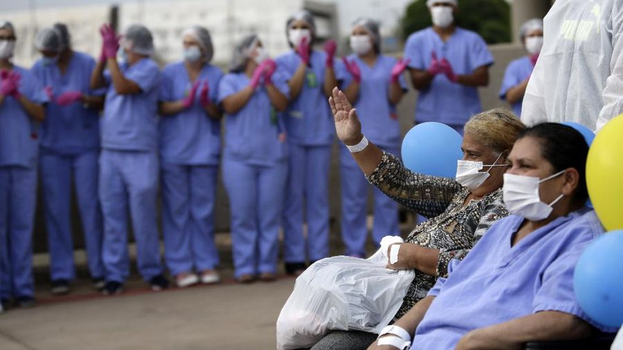Medical workers celebrate as the last three patients are released from a field hospital at the National Stadium Mane Garrincha, after recuperating from COVID-19, in Brasilia, Brazil, Thursday, Oct. 15, 2020. (AP Photo/Eraldo Peres)