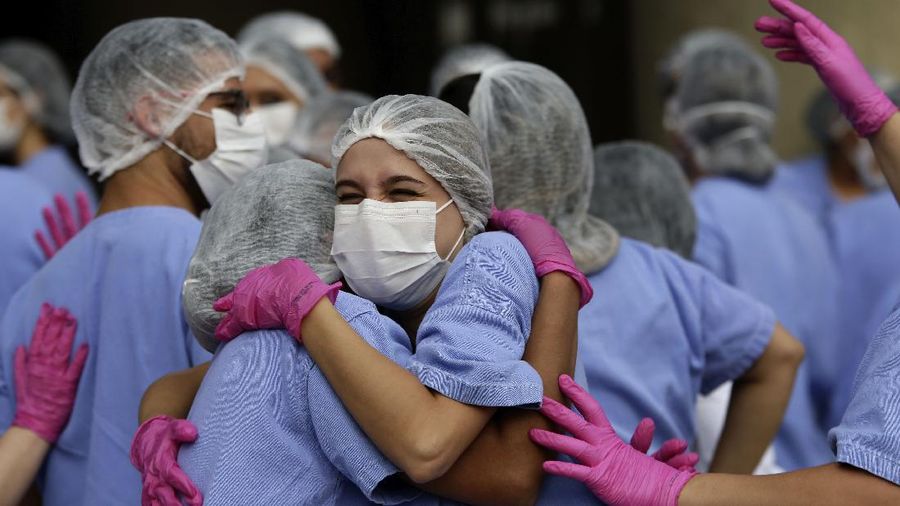 Medical workers celebrate as the last three patients are released from a field hospital at the National Stadium Mane Garrincha, after recuperating from COVID-19, in Brasilia, Brazil, Thursday, Oct. 15, 2020. (AP Photo/Eraldo Peres)