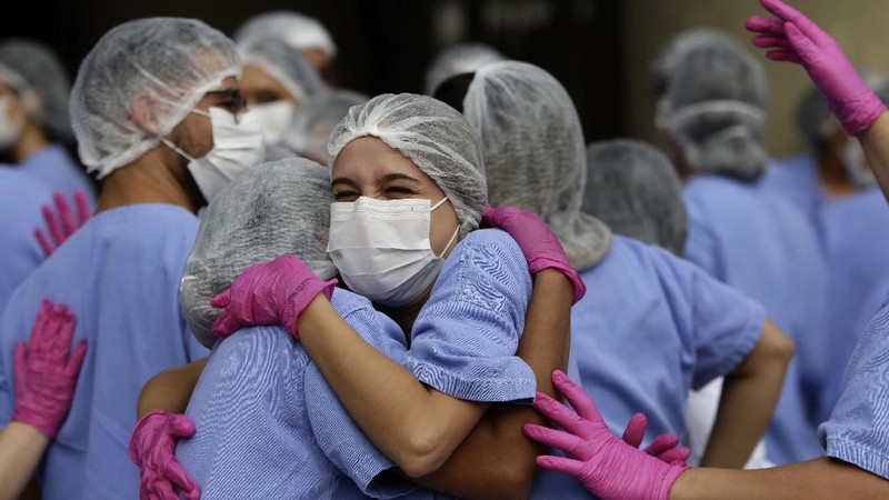 Medical workers celebrate as the last three patients are released from a field hospital at the National Stadium Mane Garrincha, after recuperating from COVID-19, in Brasilia, Brazil, Thursday, Oct. 15, 2020. (AP Photo/Eraldo Peres)