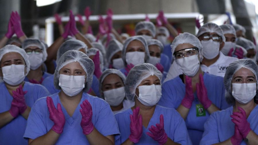 A medical worker shows her life sign tattoo while she and fellow workers celebrate as the last three patients are released from a field hospital at the National Stadium Mane Garrincha, after recuperating from COVID-19, in Brasilia, Brazil, Thursday, Oct. 15, 2020. (AP Photo/Eraldo Peres)