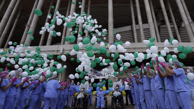 Medical workers celebrate as the last three patients are released from a field hospital at the National Stadium Mane Garrincha, after recuperating from COVID-19, in Brasilia, Brazil, Thursday, Oct. 15, 2020. (AP Photo/Eraldo Peres)