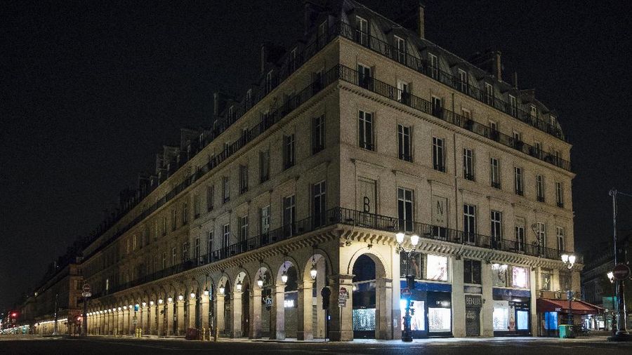 People walk in the empty center of Lyon, central France, Saturday, Oct. 17, 2020. France is deploying 12,000 police officers to enforce a new curfew that came into effect Friday night for the next month to slow the virus spread, and will spend another 1 billion euros to help businesses hit by the new restrictions. (AP Photo/Laurent Cipriani)