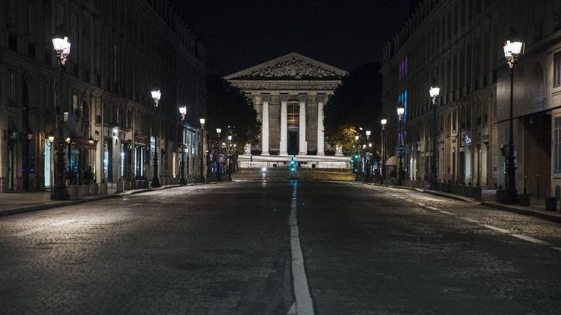 People walk in the empty center of Lyon, central France, Saturday, Oct. 17, 2020. France is deploying 12,000 police officers to enforce a new curfew that came into effect Friday night for the next month to slow the virus spread, and will spend another 1 billion euros to help businesses hit by the new restrictions. (AP Photo/Laurent Cipriani)