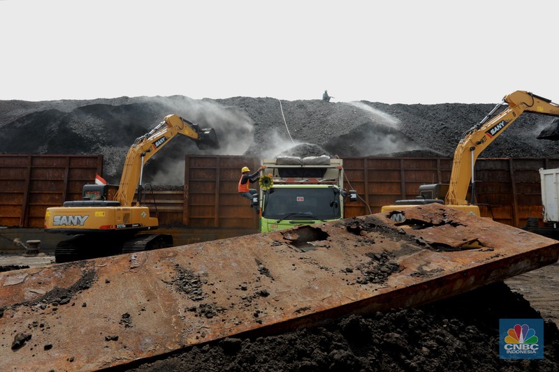 Pekerja melakukan bongkar muat batubara di Terminal Tanjung Priok, Jakarta, Kamis (6/1/2022). Pemerintah memutuskan untuk menyetop ekspor batu bara pada 1–31 Januari 2022 guna menjamin terpenuhinya pasokan komoditas tersebut untuk pembangkit listrik tenaga uap (PLTU) milik PLN dan independent power producer (IPP) dalam negeri. Kurangnya pasokan batubara dalam negeri ini akan berdampak kepada lebih dari 10 juta pelanggan PLN, mulai dari masyarakat umum hingga industri, di wilayah Jawa, Madura, Bali (Jamali) dan non-Jamali. (CNBC Indonesia/ Tri Susilo)