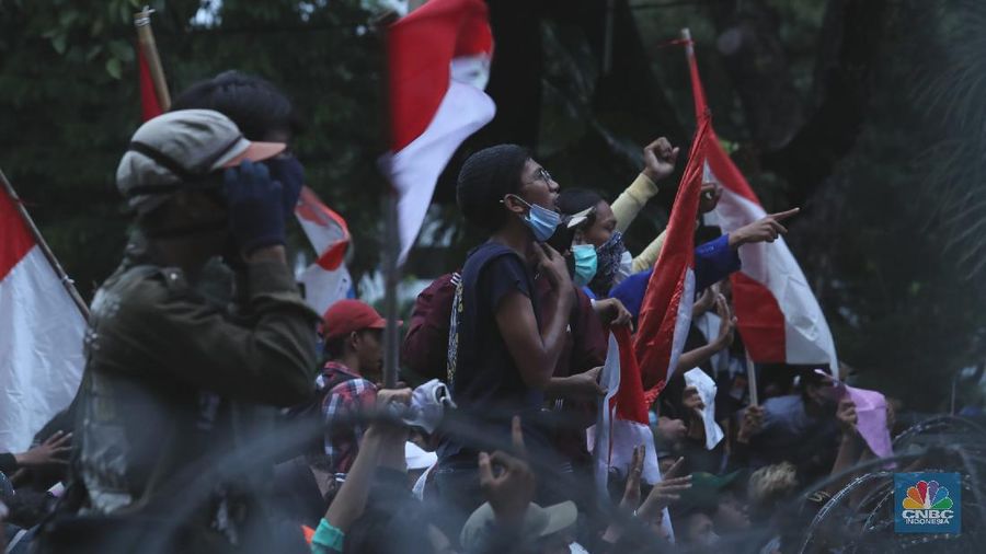 Aksi massa  yang menggelar demo menolak Omnibus Law UU Cipta Kerja menaiki Patung Kuda Arjuna Wiwaha yang berlokasi di Jalan Medan Merdeka Barat, Jakarta Pusat, Selasa (20/10). Mereka lalu mengibarkan bendera merah putih di patung tersebut. (CNBC Indonesia/Tri Susilo)