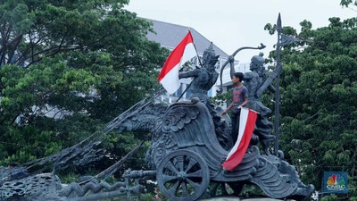 Aksi massa  yang menggelar demo menolak Omnibus Law UU Cipta Kerja menaiki Patung Kuda Arjuna Wiwaha yang berlokasi di Jalan Medan Merdeka Barat, Jakarta Pusat, Selasa (20/10). Mereka lalu mengibarkan bendera merah putih di patung tersebut. (CNBC Indonesia/Tri Susilo)