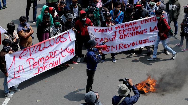 Massa aksi unjuk rasa yang menamakan diri Gerakan Soekarno Muda masuk ke barisan massa dan membakar ban di depan barikade sekitar patung kuda. (վ/Tri Susilo)