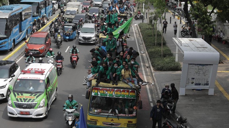 Massa Mahasiswa  konvoi dengan bus di Kawasan Salemba menuju Istana untuk Aksi unjuk rasa menentang UU Cipta Kerja, Selasa (20/10/2020). Ketua Konfederasi Aliansi Serikat Buruh Indonesia (KASBI) Nining Elitos mengatakan demonstrasi digelar berbarengan dengan momen satu tahun Presiden Joko Widodo (Jokowi) dan Wakil Presiden KH Ma'ruf Amin. Merespons aksi massa, Kapolres Jakarta Pusat Kombes Heru Novianto mengatakan, pihaknya telah menerima laporan intelijen terkait rencana aksi massa. Mereka yang berunjuk rasa berasal dari mahasiswa hingga buruh. (վ/ Muhammad Sabki(
