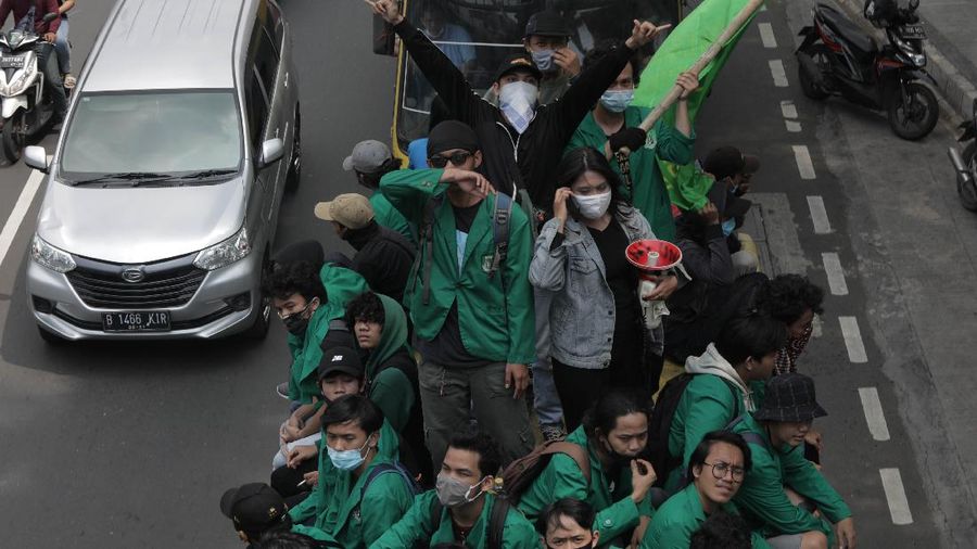Massa Mahasiswa  konvoi dengan bus di Kawasan Salemba menuju Istana untuk Aksi unjuk rasa menentang UU Cipta Kerja, Selasa (20/10/2020). Ketua Konfederasi Aliansi Serikat Buruh Indonesia (KASBI) Nining Elitos mengatakan demonstrasi digelar berbarengan dengan momen satu tahun Presiden Joko Widodo (Jokowi) dan Wakil Presiden KH Ma'ruf Amin. Merespons aksi massa, Kapolres Jakarta Pusat Kombes Heru Novianto mengatakan, pihaknya telah menerima laporan intelijen terkait rencana aksi massa. Mereka yang berunjuk rasa berasal dari mahasiswa hingga buruh. (վ/ Muhammad Sabki(