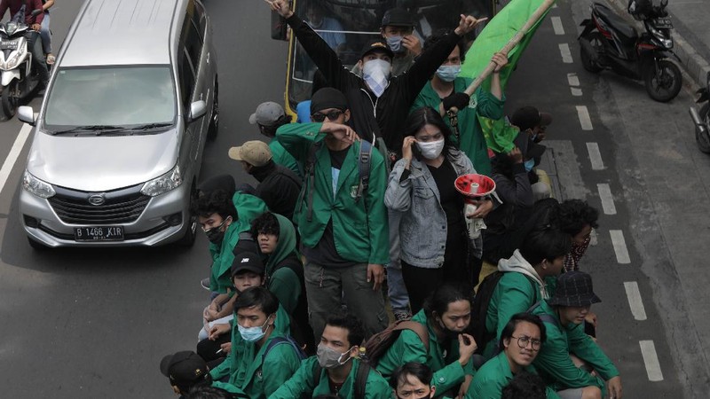 Massa Mahasiswa  konvoi dengan bus di Kawasan Salemba menuju Istana untuk Aksi unjuk rasa menentang UU Cipta Kerja, Selasa (20/10/2020). Ketua Konfederasi Aliansi Serikat Buruh Indonesia (KASBI) Nining Elitos mengatakan demonstrasi digelar berbarengan dengan momen satu tahun Presiden Joko Widodo (Jokowi) dan Wakil Presiden KH Ma'ruf Amin. Merespons aksi massa, Kapolres Jakarta Pusat Kombes Heru Novianto mengatakan, pihaknya telah menerima laporan intelijen terkait rencana aksi massa. Mereka yang berunjuk rasa berasal dari mahasiswa hingga buruh. (վ/ Muhammad Sabki(