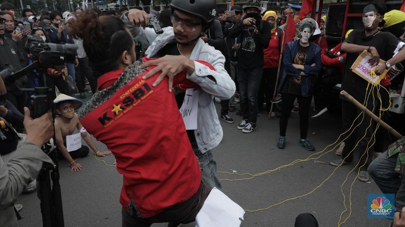 Massa mahasiswa tengah melakukan demonstrasi tolak omnibus law UU Cipta Kerja di persimpangan Gedung Antara, Jakarta Pusat, Selasa 20/10. Di sela demonstrasi, mereka melakukan aksi teatrikal. Pantauan CNBC Indonesia, Selasa (20/10/2020), pukul 16.45 WIB, mahasiswa mulai memadati sekitar kawasan Patung Kuda. Mereka berorasi menyampaikan penolakan atas UU Cipta Kerja. Selain berorasi, mereka melakukan aksi teatrikal. Tampak seorang pria yang berpenampilan lusuh memakai topeng Jokowi dan ketua DPR.  (CNBC Indonesia/ Muhammad Sabki)