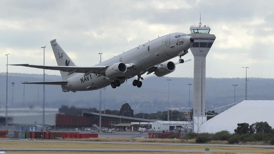 A U.S. Navy P-8 Poseidon aircraft flies out from Perth, Australia, International Airport Wednesday, April 16, 2014, to assist in the search for the missing Malaysia Airlines Flight 370 in the southern Indian Ocean. A robotic submarine looking for the lost Malaysian jet is continuing its second seabed search on as up to 14 planes were to take to the skies for some of the final sweeps of the Indian Ocean for floating debris from the ill-fated airliner. (AP Photo/Greg Wood, Pool)