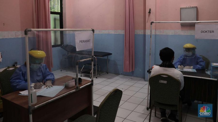 Dokter memperagakan proses vaksinasi saat simulasi pemberian vaksin di Puskesmas Depok, Jawa Barat, Kamis (22/10). Pemerintah Kota Depok akan menggelar simulasi pemberian vaksin corona. Pemberian vaksin idealnya sebanyak 60 persen dari jumlah penduduk Kota Depok. Adapun yang hadir bukanlah warga sungguhan yang hendak divaksin. Hanya perwakilan dari Pemkot Depok saja. Terdapat sejumlah tahapan alur yang akan diterapkan Pemerintah Kota Depok dalam pemberian vaksin. Orang yang masuk dalam kriteria mendapat vaksin akan diundang untuk datang ke puskesmas. Nantinya mereka duduk di ruang tunggu dengan penerapan protokol kesehatan. Mereka kemudian menunggu giliran dipanggil petugas. Setelah itu masuk ke ruangan untuk disuntik vaksin. Orang yang telah divaksin akan diregistrasi petugas guna memantau perkembangannya secara berkala.  (CNBC Indonesia/ Muhammad Sabki)
