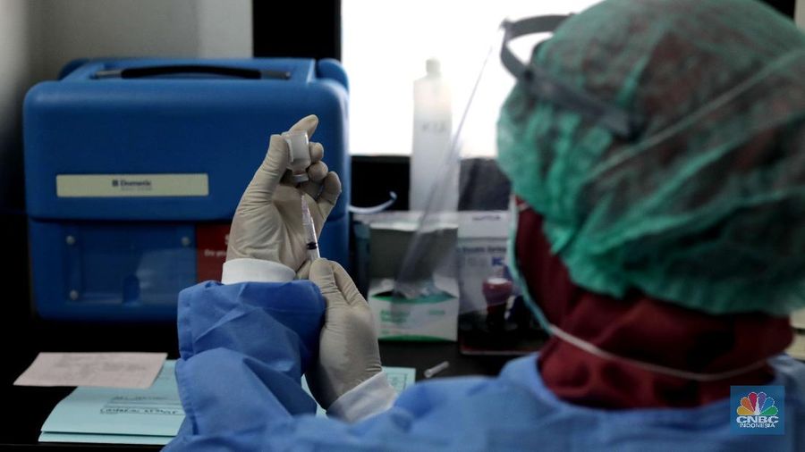 Dokter memperagakan proses vaksinasi saat simulasi pemberian vaksin di Puskesmas Depok, Jawa Barat, Kamis (22/10). Pemerintah Kota Depok akan menggelar simulasi pemberian vaksin corona. Pemberian vaksin idealnya sebanyak 60 persen dari jumlah penduduk Kota Depok. Adapun yang hadir bukanlah warga sungguhan yang hendak divaksin. Hanya perwakilan dari Pemkot Depok saja. Terdapat sejumlah tahapan alur yang akan diterapkan Pemerintah Kota Depok dalam pemberian vaksin. Orang yang masuk dalam kriteria mendapat vaksin akan diundang untuk datang ke puskesmas. Nantinya mereka duduk di ruang tunggu dengan penerapan protokol kesehatan. Mereka kemudian menunggu giliran dipanggil petugas. Setelah itu masuk ke ruangan untuk disuntik vaksin. Orang yang telah divaksin akan diregistrasi petugas guna memantau perkembangannya secara berkala.  (CNBC Indonesia/ Muhammad Sabki)