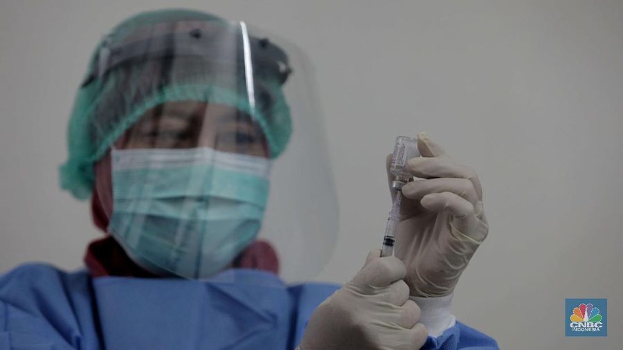 Dokter memperagakan proses vaksinasi saat simulasi pemberian vaksin di Puskesmas Depok, Jawa Barat, Kamis (22/10). Pemerintah Kota Depok akan menggelar simulasi pemberian vaksin corona. Pemberian vaksin idealnya sebanyak 60 persen dari jumlah penduduk Kota Depok. Adapun yang hadir bukanlah warga sungguhan yang hendak divaksin. Hanya perwakilan dari Pemkot Depok saja. Terdapat sejumlah tahapan alur yang akan diterapkan Pemerintah Kota Depok dalam pemberian vaksin. Orang yang masuk dalam kriteria mendapat vaksin akan diundang untuk datang ke puskesmas. Nantinya mereka duduk di ruang tunggu dengan penerapan protokol kesehatan. Mereka kemudian menunggu giliran dipanggil petugas. Setelah itu masuk ke ruangan untuk disuntik vaksin. Orang yang telah divaksin akan diregistrasi petugas guna memantau perkembangannya secara berkala.  (CNBC Indonesia/ Muhammad Sabki)