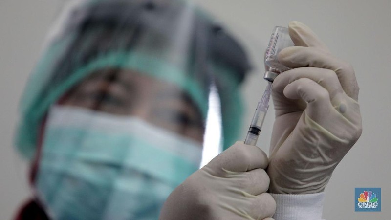 Dokter memperagakan proses vaksinasi saat simulasi pemberian vaksin di Puskesmas Depok, Jawa Barat, Kamis (22/10). Pemerintah Kota Depok akan menggelar simulasi pemberian vaksin corona. Pemberian vaksin idealnya sebanyak 60 persen dari jumlah penduduk Kota Depok. Adapun yang hadir bukanlah warga sungguhan yang hendak divaksin. Hanya perwakilan dari Pemkot Depok saja. Terdapat sejumlah tahapan alur yang akan diterapkan Pemerintah Kota Depok dalam pemberian vaksin. Orang yang masuk dalam kriteria mendapat vaksin akan diundang untuk datang ke puskesmas. Nantinya mereka duduk di ruang tunggu dengan penerapan protokol kesehatan. Mereka kemudian menunggu giliran dipanggil petugas. Setelah itu masuk ke ruangan untuk disuntik vaksin. Orang yang telah divaksin akan diregistrasi petugas guna memantau perkembangannya secara berkala.  (CNBC Indonesia/ Muhammad Sabki)