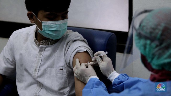Simulasi pemberian vaksin Covid-19 Dokter memperagakan proses vaksinasi saat simulasi pemberian vaksin di Puskesmas Depok, Jawa Barat, Kamis (22/10). Pemerintah Kota Depok akan menggelar simulasi pemberian vaksin corona. Pemberian vaksin idealnya sebanyak 60 persen dari jumlah penduduk Kota Depok. Adapun yang hadir bukanlah warga sungguhan yang hendak divaksin. Hanya perwakilan dari Pemkot Depok saja. Terdapat sejumlah tahapan alur yang akan diterapkan Pemerintah Kota Depok dalam pemberian vaksin. Orang yang masuk dalam kriteria mendapat vaksin akan diundang untuk datang ke puskesmas. Nantinya mereka duduk di ruang tunggu dengan penerapan protokol kesehatan. Mereka kemudian menunggu giliran dipanggil petugas. Setelah itu masuk ke ruangan untuk disuntik vaksin. Orang yang telah divaksin akan diregistrasi petugas guna memantau perkembangannya secara berkala. (CNBC Indonesia/ Muhammad Sabki)