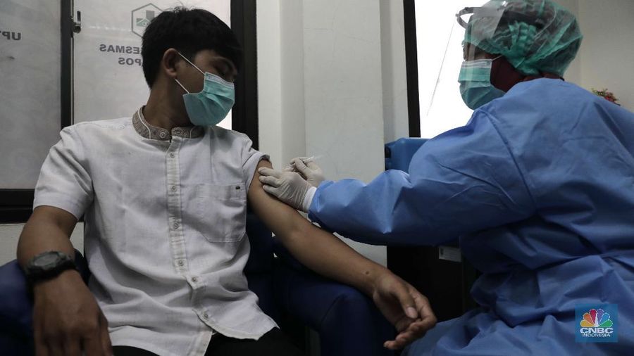Dokter memperagakan proses vaksinasi saat simulasi pemberian vaksin di Puskesmas Depok, Jawa Barat, Kamis (22/10). Pemerintah Kota Depok akan menggelar simulasi pemberian vaksin corona. Pemberian vaksin idealnya sebanyak 60 persen dari jumlah penduduk Kota Depok. Adapun yang hadir bukanlah warga sungguhan yang hendak divaksin. Hanya perwakilan dari Pemkot Depok saja. Terdapat sejumlah tahapan alur yang akan diterapkan Pemerintah Kota Depok dalam pemberian vaksin. Orang yang masuk dalam kriteria mendapat vaksin akan diundang untuk datang ke puskesmas. Nantinya mereka duduk di ruang tunggu dengan penerapan protokol kesehatan. Mereka kemudian menunggu giliran dipanggil petugas. Setelah itu masuk ke ruangan untuk disuntik vaksin. Orang yang telah divaksin akan diregistrasi petugas guna memantau perkembangannya secara berkala.  (CNBC Indonesia/ Muhammad Sabki)