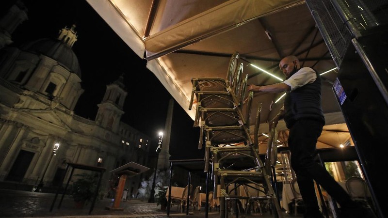 A view of an empty Piazza Navona Square after the start of a curfew, Saturday, Oct. 24, 2020. Italian Premier Giuseppe Conte, who imposed severe-stay-at-home limits on citizens early on, then gradually eased travel and other restrictions, has been leaving it up to regional governors in this current surge of infections to order restrictions such as overnight curfews, including in places like Rome, Milan and Naples. (AP Photo/Alessandra Tarantino)