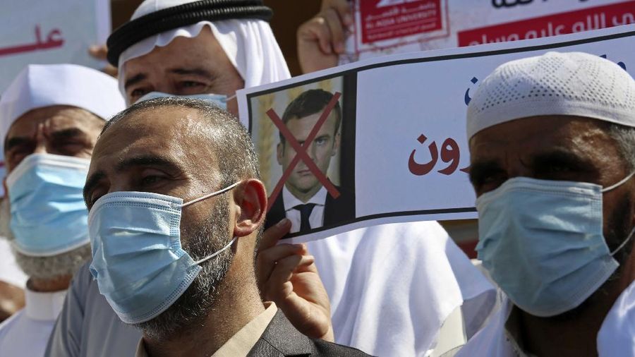 Seorang pria memegang gambar Macron dengan cetakan sepatu di atasnya ketika pengunjuk rasa Turki meneriakkan slogan-slogan menentang Prancis selama demonstrasi atas kartun Nabi Muhammad, di Istanbul. (AP/Adel Hana)