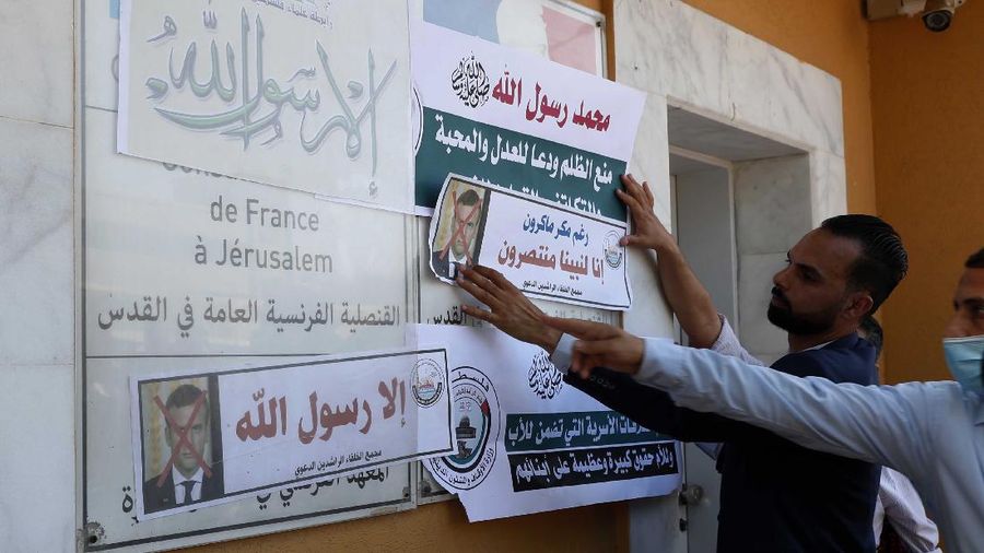 Seorang pria memegang gambar Macron dengan cetakan sepatu di atasnya ketika pengunjuk rasa Turki meneriakkan slogan-slogan menentang Prancis selama demonstrasi atas kartun Nabi Muhammad, di Istanbul. (AP/Adel Hana)
