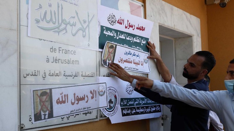 Seorang pria memegang gambar Macron dengan cetakan sepatu di atasnya ketika pengunjuk rasa Turki meneriakkan slogan-slogan menentang Prancis selama demonstrasi atas kartun Nabi Muhammad, di Istanbul. (AP/Adel Hana)