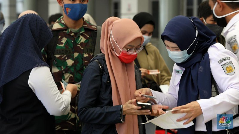 Petugas melakukan pengecekann tiket dan surat bebas covid-19 penumpang sebelum memasuki ruang tunggu keberangkatan di Stasiun Pasar Senen, Jakarta, Rabu (28/10/2020). (CNBC Indonesia/Andrean Kristianto)