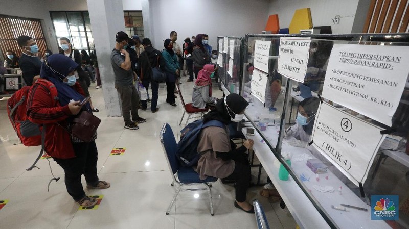 Petugas melakukan pengecekann tiket dan surat bebas covid-19 penumpang sebelum memasuki ruang tunggu keberangkatan di Stasiun Pasar Senen, Jakarta, Rabu (28/10/2020). (CNBC Indonesia/Andrean Kristianto)