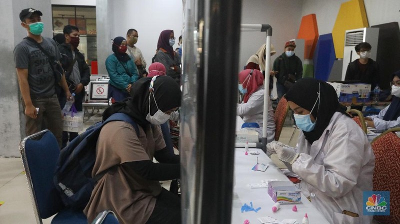 Petugas melakukan pengecekann tiket dan surat bebas covid-19 penumpang sebelum memasuki ruang tunggu keberangkatan di Stasiun Pasar Senen, Jakarta, Rabu (28/10/2020). (CNBC Indonesia/Andrean Kristianto)