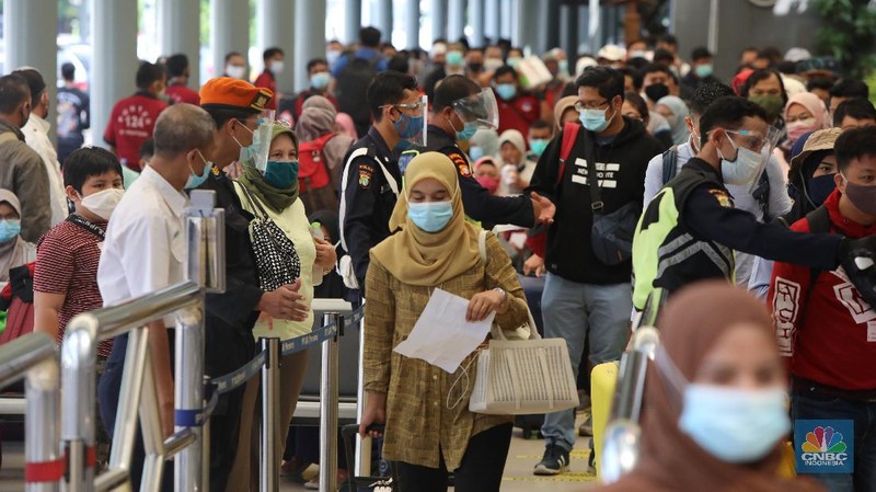 Petugas melakukan pengecekann tiket dan surat bebas covid-19 penumpang sebelum memasuki ruang tunggu keberangkatan di Stasiun Pasar Senen, Jakarta, Rabu (28/10/2020). (CNBC Indonesia/Andrean Kristianto)