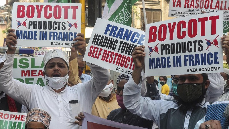 Iranian protesters hold defaced pictures of French President Emmanuel Macron during a protest against Macron and the publishing of caricatures of the Prophet Muhammad they deem blasphemous, in front of French Embassy in Tehran, Iran, Wednesday, Oct. 28, 2020. Macron has vowed his country will not back down from its secular ideals and defense of free speech. (AP Photo/Ebrahim Noroozi)