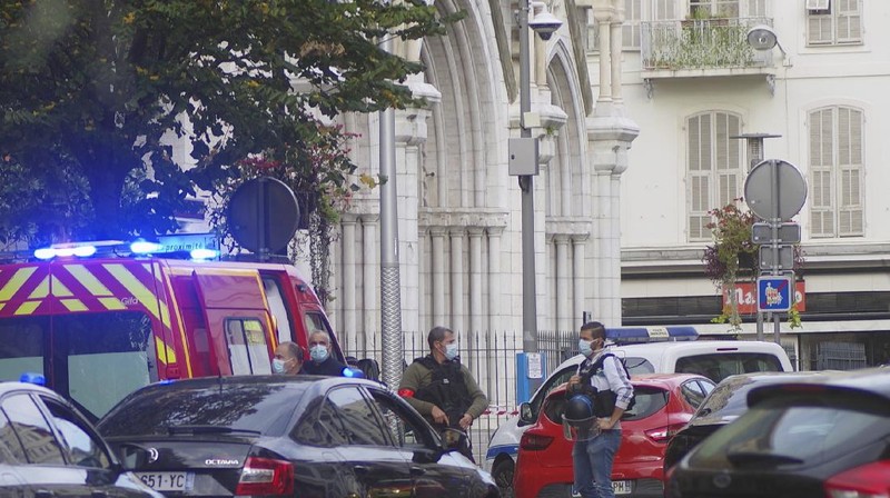 French policemen stand next to Notre Dame church after a knife attack, in Nice, France, Thursday, Oct. 29, 2020. French anti-terrorism prosecutors are investigating a knife attack at a church in the Mediterranean city of Nice that killed two people and injured several others. (AP Photo/Alexis Gilli)