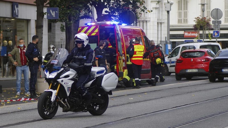 French policemen stand next to Notre Dame church after a knife attack, in Nice, France, Thursday, Oct. 29, 2020. French anti-terrorism prosecutors are investigating a knife attack at a church in the Mediterranean city of Nice that killed two people and injured several others. (AP Photo/Alexis Gilli)