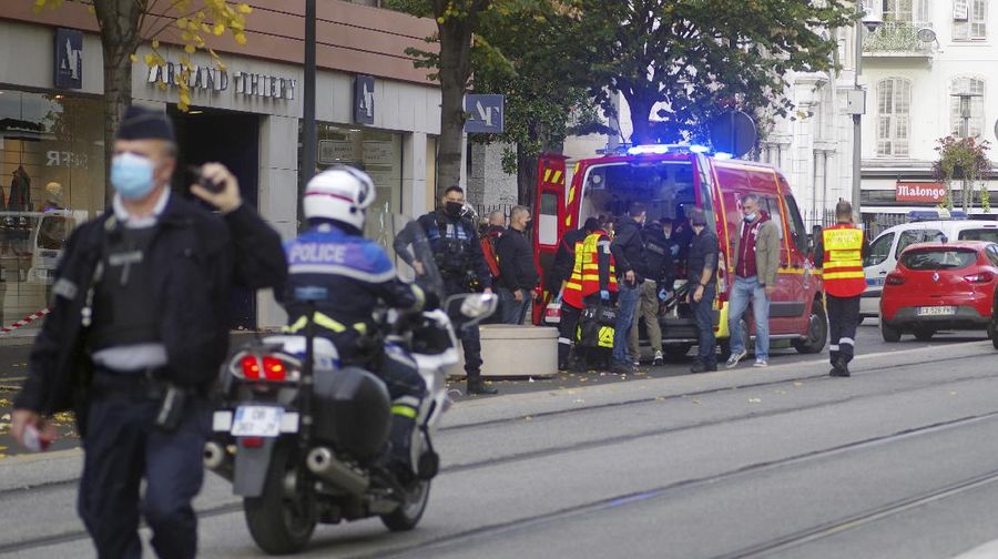 French policemen stand next to Notre Dame church after a knife attack, in Nice, France, Thursday, Oct. 29, 2020. French anti-terrorism prosecutors are investigating a knife attack at a church in the Mediterranean city of Nice that killed two people and injured several others. (AP Photo/Alexis Gilli)
