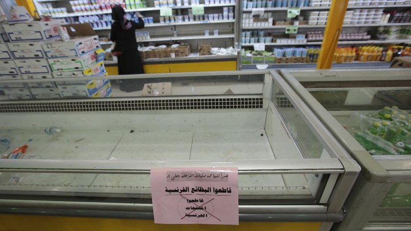A worker removes French products from a supermarket, in Sanaa, Yemen, Monday, Oct. 26, 2020. Muslims in the Middle East and beyond on Monday called for boycotts of French products and for protests over caricatures of the Prophet Muhammad they deem insulting and blasphemous, but France's president has vowed his country will not back down from its secular ideals and defense of free speech. (AP Photo/Hani Mohammed)