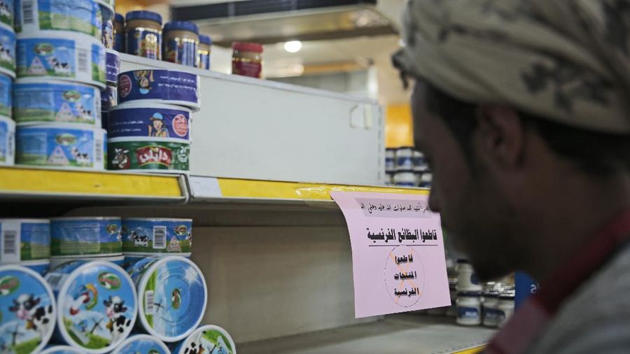 A worker removes French products from a supermarket, in Sanaa, Yemen, Monday, Oct. 26, 2020. Muslims in the Middle East and beyond on Monday called for boycotts of French products and for protests over caricatures of the Prophet Muhammad they deem insulting and blasphemous, but France's president has vowed his country will not back down from its secular ideals and defense of free speech. (AP Photo/Hani Mohammed)