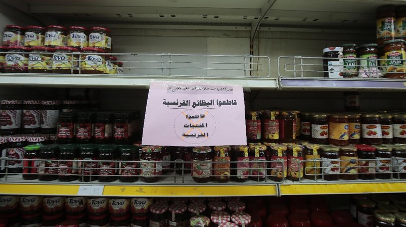 A worker removes French products from a supermarket, in Sanaa, Yemen, Monday, Oct. 26, 2020. Muslims in the Middle East and beyond on Monday called for boycotts of French products and for protests over caricatures of the Prophet Muhammad they deem insulting and blasphemous, but France's president has vowed his country will not back down from its secular ideals and defense of free speech. (AP Photo/Hani Mohammed)