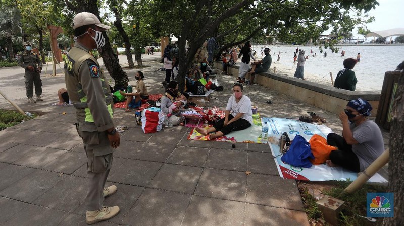 Wisatawan menikmati suasana Pantai Lagoon, Ancol, Jakarta, Jumat (30/10/2020). Libur Nasional dan Cuti bersama dimanfaatkan warga Jakarta untuk bertamasya ke tempat wisata di Jakarta.  (CNBC Indonesia/Andrean Kristianto)