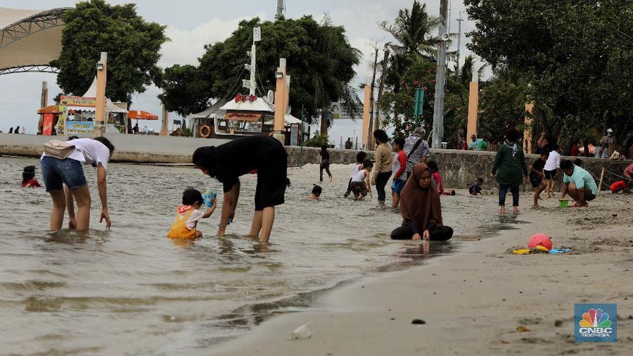 Wisatawan menikmati suasana Pantai Lagoon, Ancol, Jakarta, Jumat (30/10/2020). Libur Nasional dan Cuti bersama dimanfaatkan warga Jakarta untuk bertamasya ke tempat wisata di Jakarta. (CNBC Indonesia/Andrean Kristianto)
