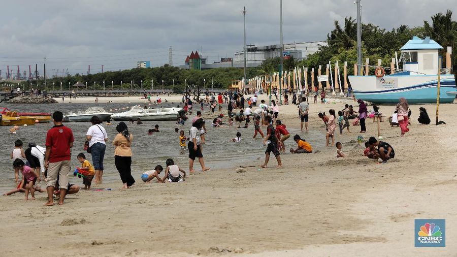 Wisatawan menikmati suasana Pantai Lagoon, Ancol, Jakarta, Jumat (30/10/2020). Libur Nasional dan Cuti bersama dimanfaatkan warga Jakarta untuk bertamasya ke tempat wisata di Jakarta.  (CNBC Indonesia/Andrean Kristianto)