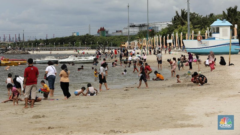Wisatawan menikmati suasana Pantai Lagoon, Ancol, Jakarta, Jumat (30/10/2020). Libur Nasional dan Cuti bersama dimanfaatkan warga Jakarta untuk bertamasya ke tempat wisata di Jakarta.  (CNBC Indonesia/Andrean Kristianto)
