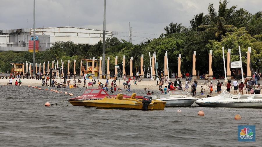 Wisatawan menikmati suasana Pantai Lagoon, Ancol, Jakarta, Jumat (30/10/2020). Libur Nasional dan Cuti bersama dimanfaatkan warga Jakarta untuk bertamasya ke tempat wisata di Jakarta.  (CNBC Indonesia/Andrean Kristianto)