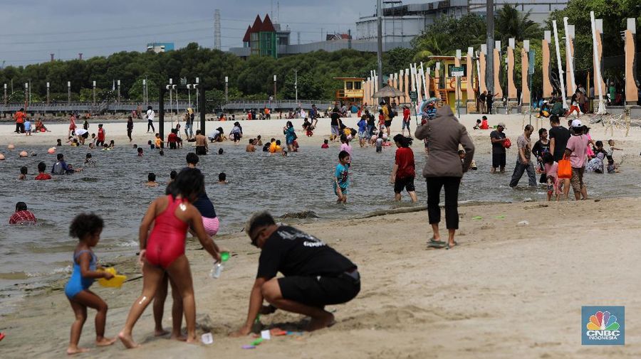 Wisatawan menikmati suasana Pantai Lagoon, Ancol, Jakarta, Jumat (30/10/2020). Libur Nasional dan Cuti bersama dimanfaatkan warga Jakarta untuk bertamasya ke tempat wisata di Jakarta.  (վ/Andrean Kristianto)