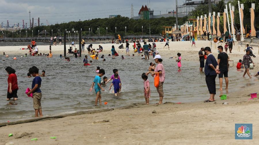 Wisatawan menikmati suasana Pantai Lagoon, Ancol, Jakarta, Jumat (30/10/2020). Libur Nasional dan Cuti bersama dimanfaatkan warga Jakarta untuk bertamasya ke tempat wisata di Jakarta.  (վ/Andrean Kristianto)