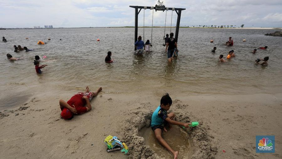 Wisatawan menikmati suasana Pantai Lagoon, Ancol, Jakarta, Jumat (30/10/2020). Libur Nasional dan Cuti bersama dimanfaatkan warga Jakarta untuk bertamasya ke tempat wisata di Jakarta. (CNBC Indonesia/Andrean Kristianto)