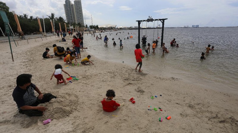 Wisatawan menikmati suasana Pantai Lagoon, Ancol, Jakarta, Jumat (30/10/2020). Libur Nasional dan Cuti bersama dimanfaatkan warga Jakarta untuk bertamasya ke tempat wisata di Jakarta.  (CNBC Indonesia/Andrean Kristianto)
