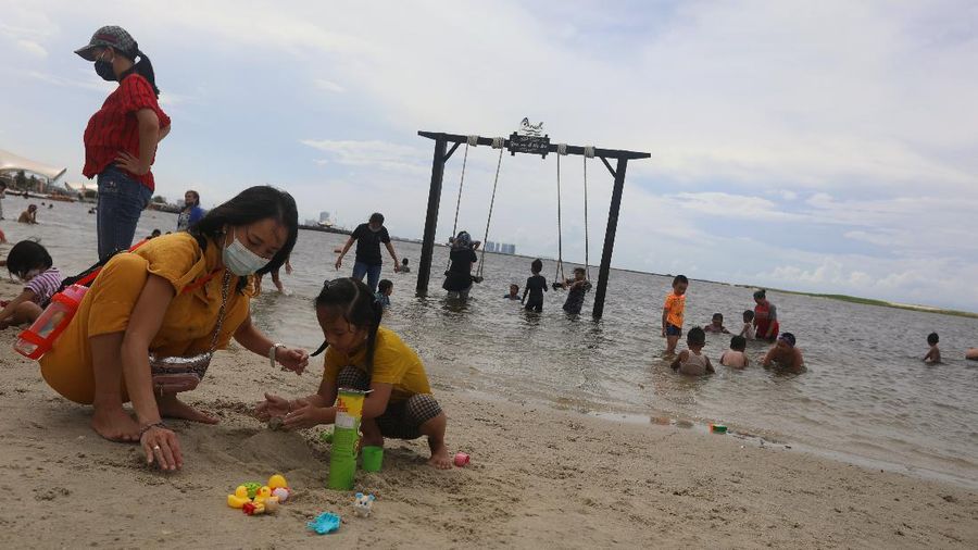 Wisatawan menikmati suasana Pantai Lagoon, Ancol, Jakarta, Jumat (30/10/2020). Libur Nasional dan Cuti bersama dimanfaatkan warga Jakarta untuk bertamasya ke tempat wisata di Jakarta.  (CNBC Indonesia/Andrean Kristianto)